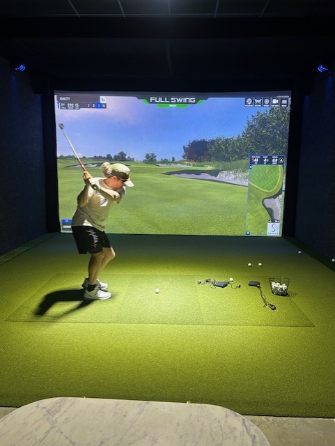Member swinging at a Full Swing simulator at Swing 365 Richmond — private indoor golf simulator near Richmond, TX
